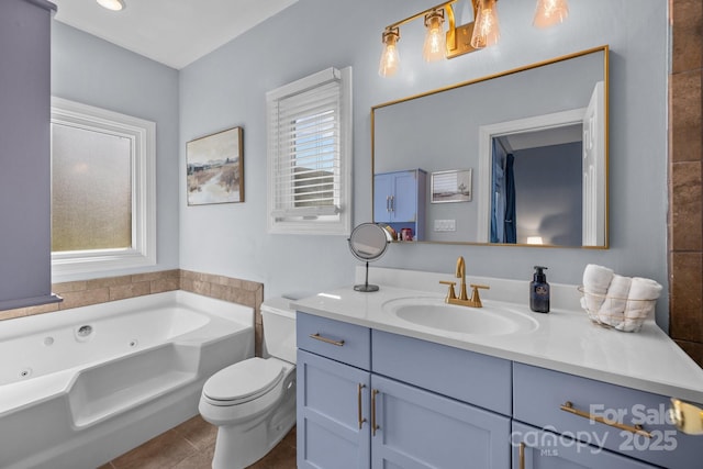 full bath with vanity, tile patterned floors, toilet, and a tub with jets