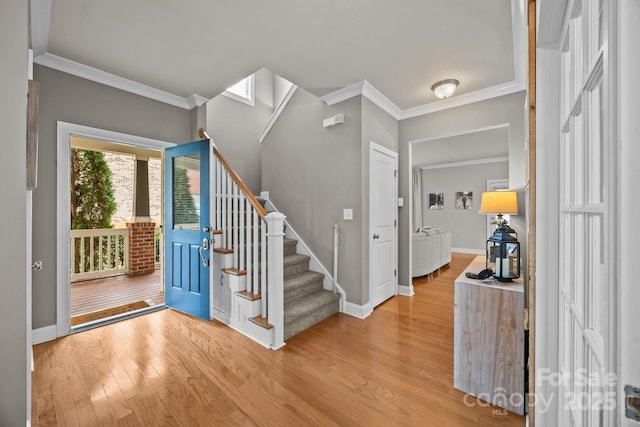 entryway featuring light wood-style flooring, stairs, crown molding, and baseboards