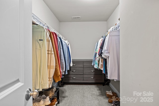 walk in closet featuring visible vents and carpet