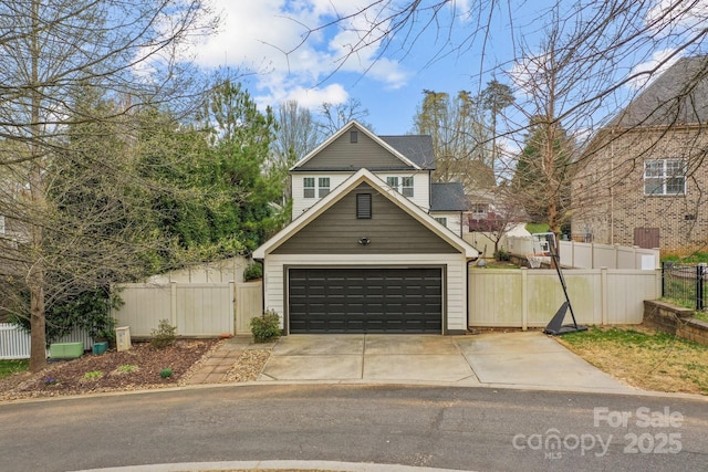 garage featuring a gate, driveway, and fence