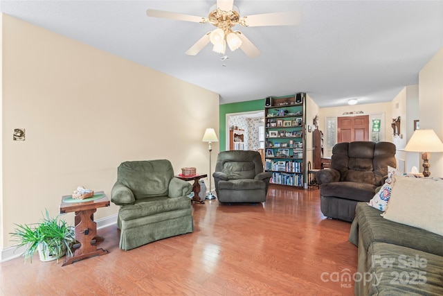 living room with baseboards, wood finished floors, and a ceiling fan