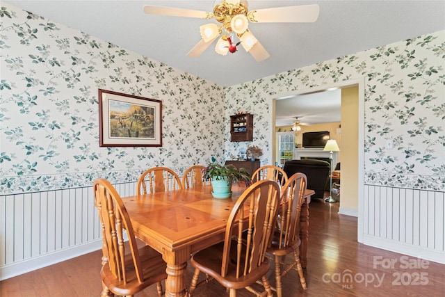 dining area featuring baseboards, wallpapered walls, a ceiling fan, and wood finished floors