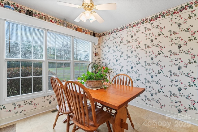 dining room with baseboards, ceiling fan, and wallpapered walls