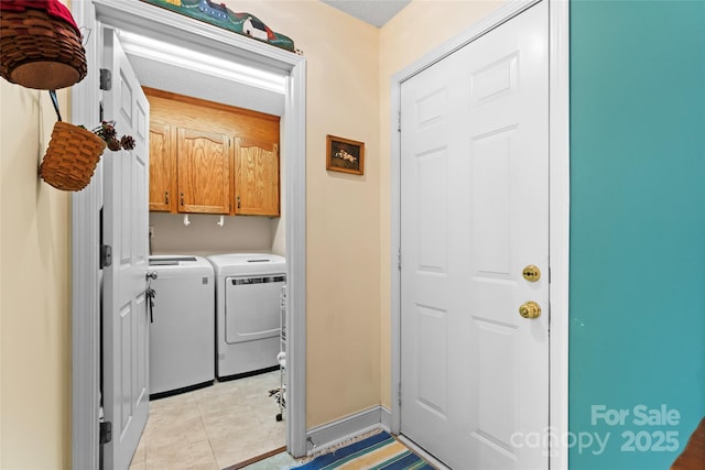 washroom featuring light tile patterned floors, cabinet space, and separate washer and dryer