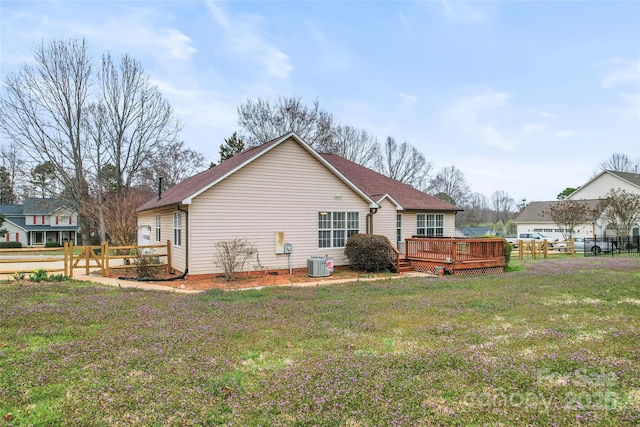 rear view of house with a wooden deck, central AC, a yard, and fence