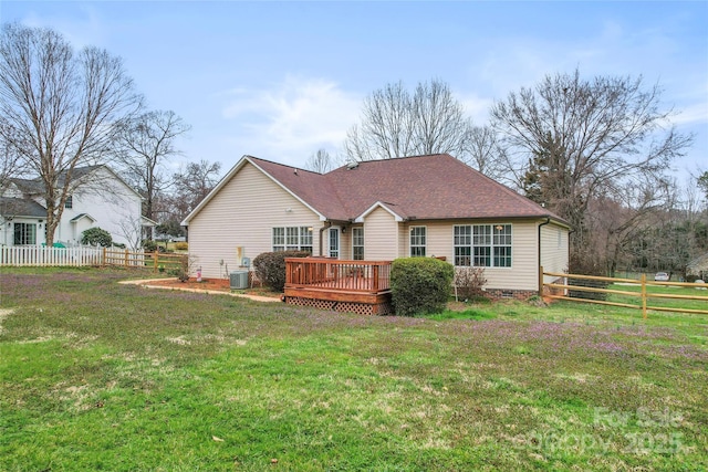 back of house with a lawn, central AC, fence, roof with shingles, and a wooden deck