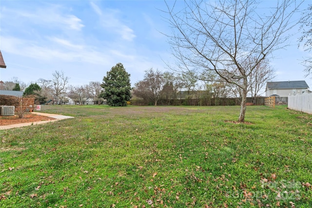 view of yard featuring central air condition unit and fence