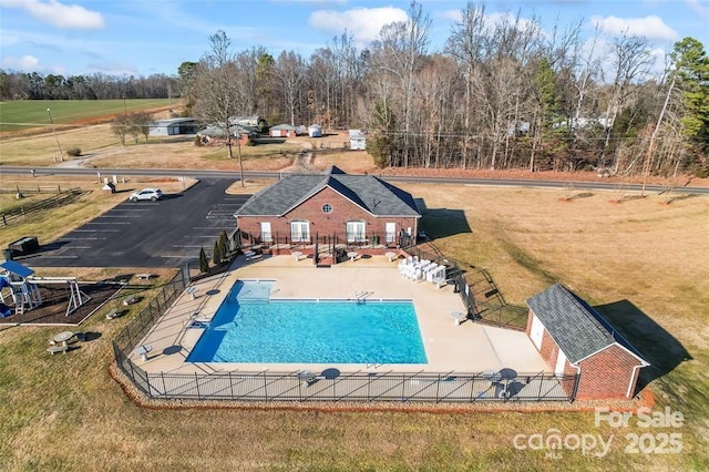 pool featuring a patio, a lawn, and fence