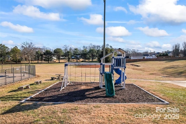 view of property's community with a lawn, playground community, and fence