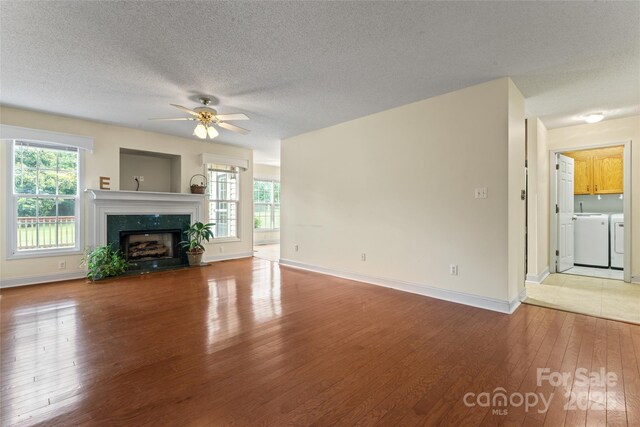 1278 Gracebrook Dr, Salisbury, NC 28147 - unfurnished living room featuring washing machine and dryer, light wood-style flooring, ceiling fan, plenty of natural light, and a textured ceiling