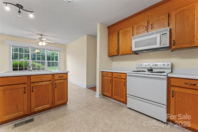 1278 Gracebrook Dr, Salisbury, NC 28147 - kitchen with white appliances, brown cabinets, a textured ceiling, light countertops, and ceiling fan