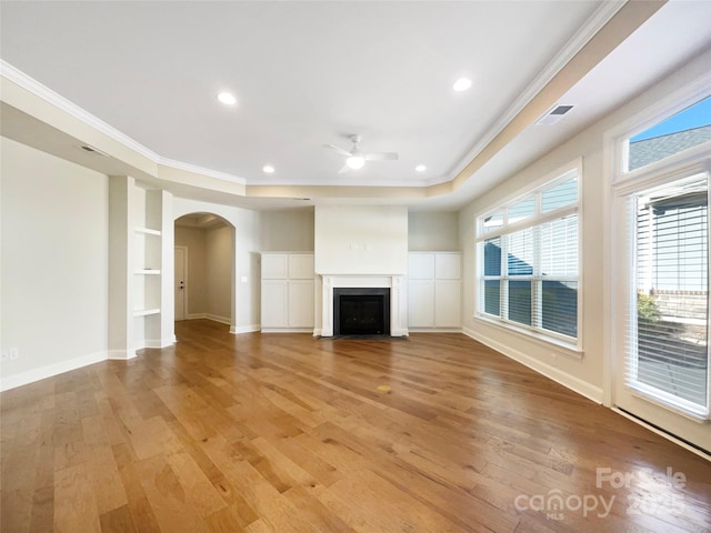 unfurnished living room with light wood-style flooring, a ceiling fan, visible vents, and ornamental molding