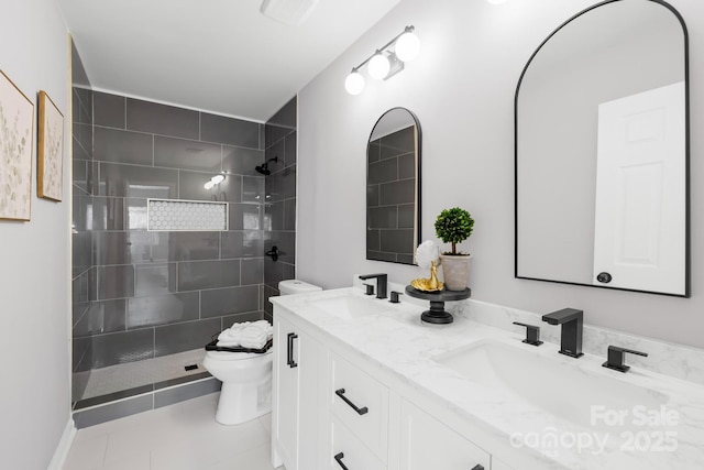 bathroom featuring double vanity, a walk in shower, toilet, and a sink