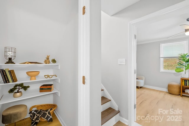 stairway featuring baseboards and wood finished floors