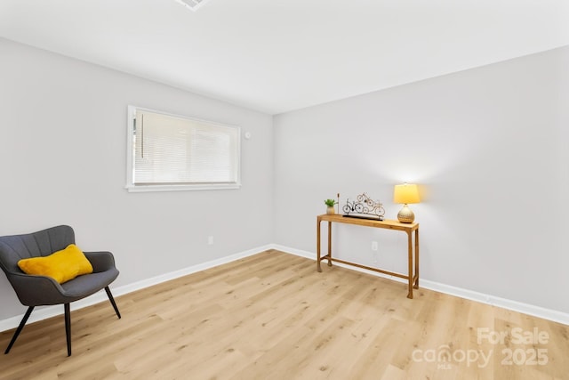 living area with baseboards and light wood-type flooring