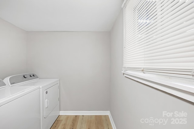 laundry room with baseboards, light wood finished floors, laundry area, and washer and clothes dryer