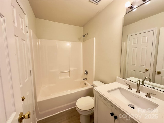 bathroom featuring vanity, bathing tub / shower combination, toilet, and wood finished floors