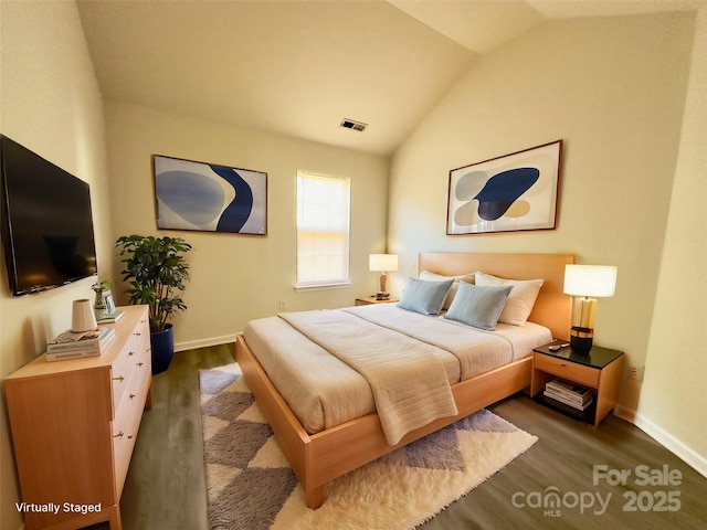 bedroom featuring baseboards, lofted ceiling, and wood finished floors