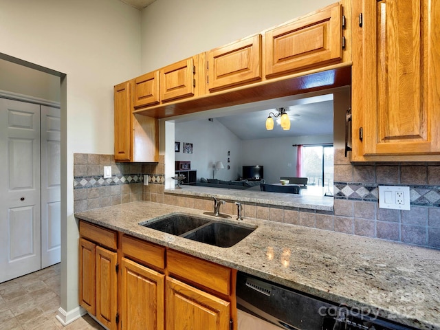 kitchen with brown cabinets, a sink, tasteful backsplash, light stone countertops, and dishwasher