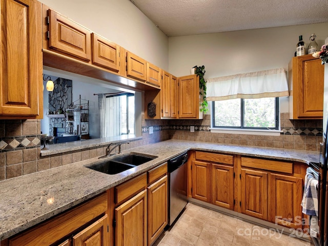 kitchen featuring brown cabinets, dishwasher, and a sink