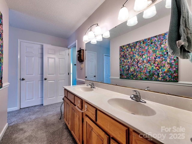 full bathroom featuring double vanity, carpet flooring, a textured ceiling, and a sink