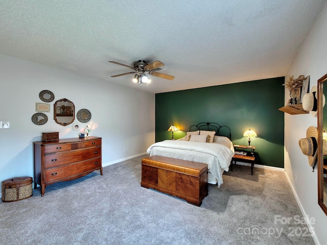 carpeted bedroom featuring a textured ceiling, a ceiling fan, and baseboards