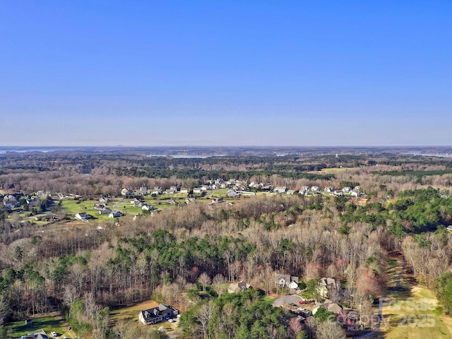 bird's eye view with a wooded view