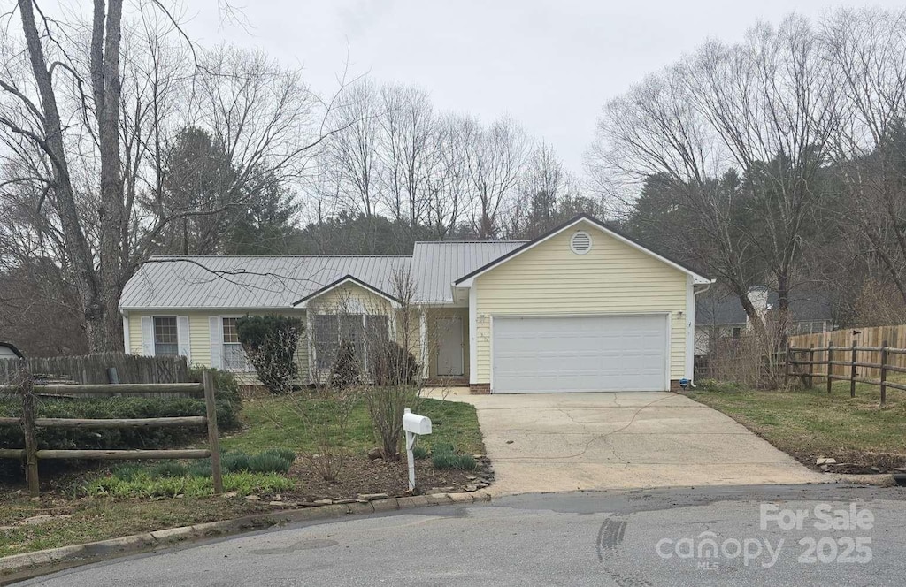 ranch-style house with concrete driveway, a garage, and fence