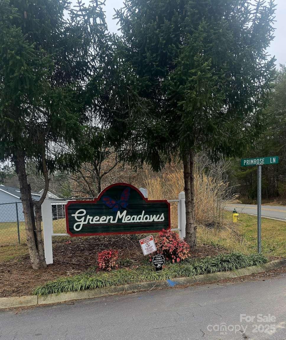 community / neighborhood sign featuring fence