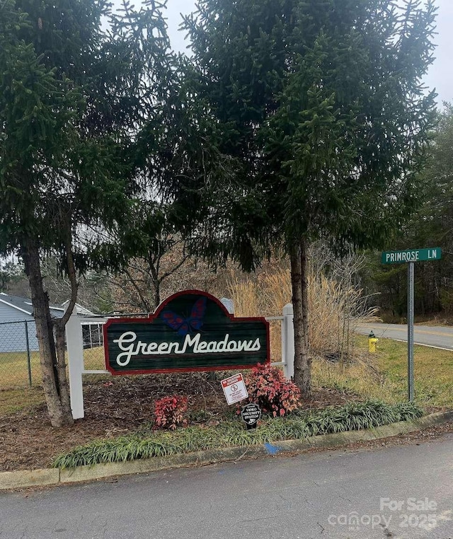 community / neighborhood sign featuring fence