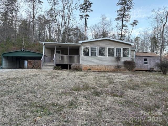 manufactured / mobile home featuring a detached carport and a porch