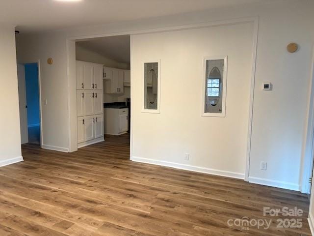 empty room with baseboards and wood finished floors