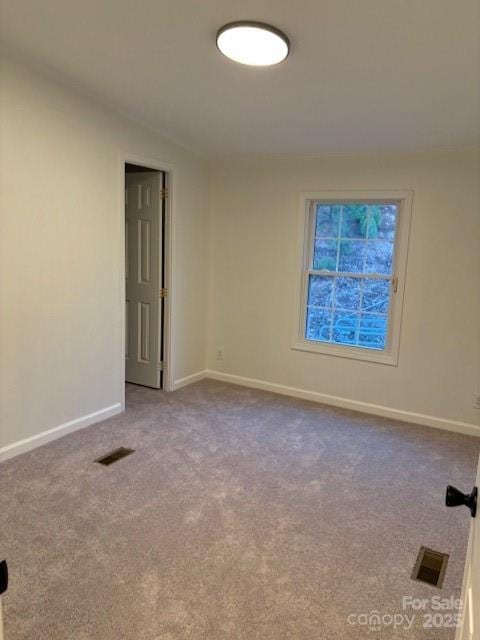 carpeted empty room featuring visible vents and baseboards