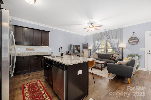kitchen featuring dark wood-style floors, open floor plan, appliances with stainless steel finishes, and a sink