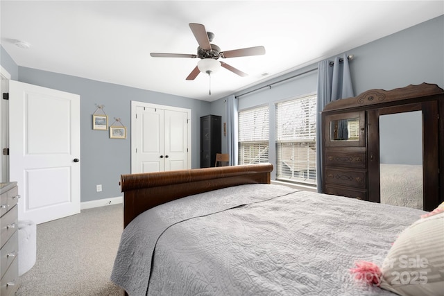 carpeted bedroom featuring a ceiling fan, baseboards, and a closet