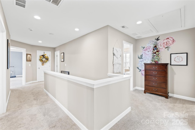 corridor featuring baseboards, recessed lighting, attic access, visible vents, and light colored carpet