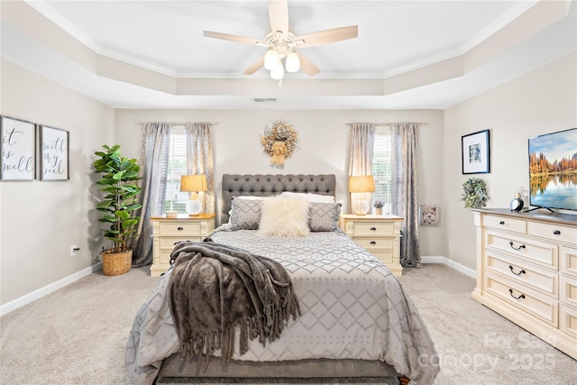 bedroom with a tray ceiling, crown molding, and light colored carpet