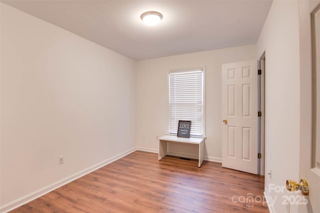 unfurnished room with wood finished floors and baseboards