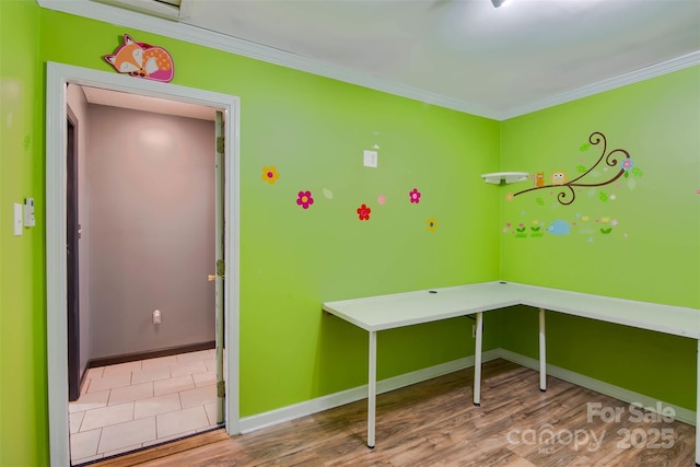 interior space featuring baseboards, wood finished floors, and crown molding