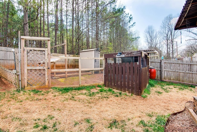 view of yard featuring an outbuilding, exterior structure, and a fenced backyard