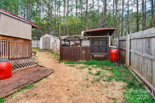 view of yard with a storage shed, an outbuilding, a fenced backyard, and exterior structure