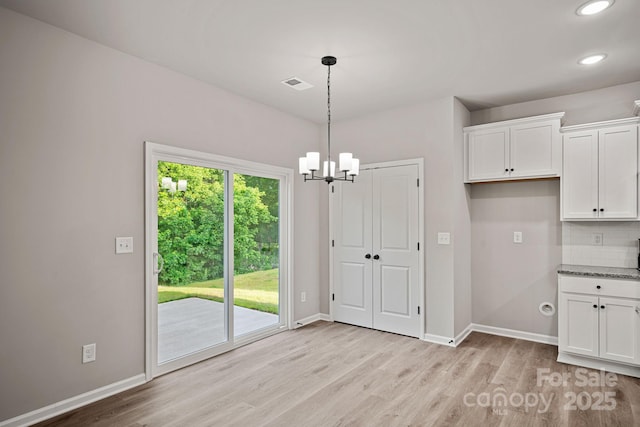 unfurnished dining area featuring visible vents, a notable chandelier, light wood-style flooring, recessed lighting, and baseboards