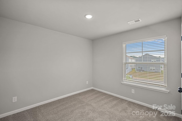 unfurnished room with visible vents, baseboards, and carpet