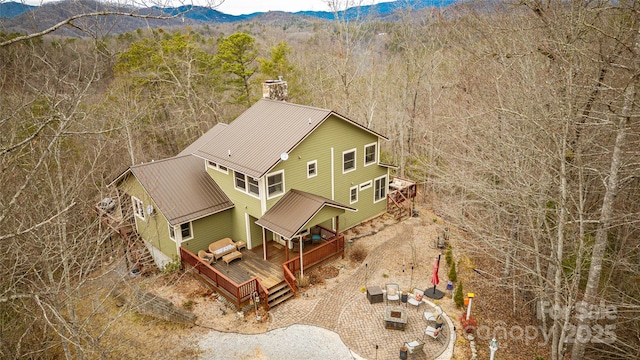 drone / aerial view with a mountain view and a view of trees