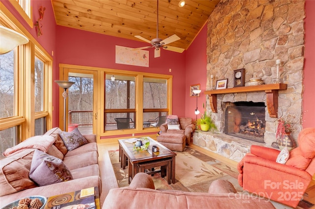 living room with wood finished floors, a fireplace, ceiling fan, wooden ceiling, and a wealth of natural light