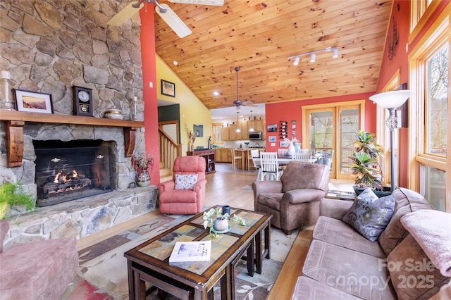 living room with a wealth of natural light, wood ceiling, ceiling fan, and wood finished floors