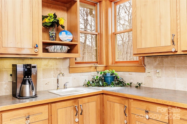 kitchen featuring tasteful backsplash, light brown cabinetry, and a sink