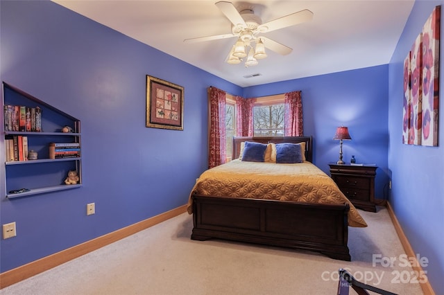 carpeted bedroom with visible vents, a ceiling fan, and baseboards