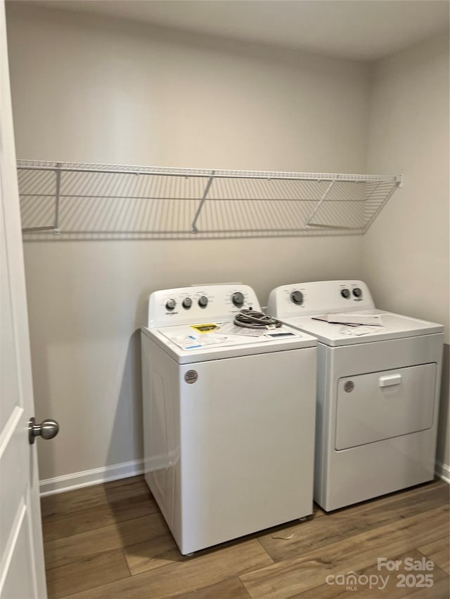 laundry area with washer and dryer, baseboards, light wood-style flooring, and laundry area