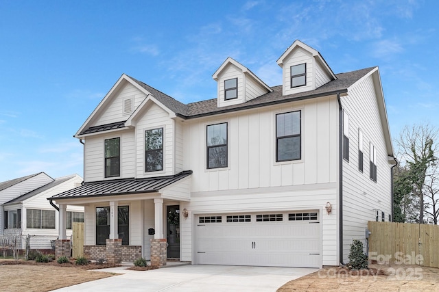 view of front of home featuring a garage, board and batten siding, concrete driveway, and fence